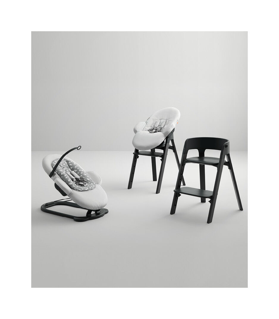 Stokke® Steps™ Bouncer with Grey Clouds textiles and highchair with Beech Black wood legs, Black seats.